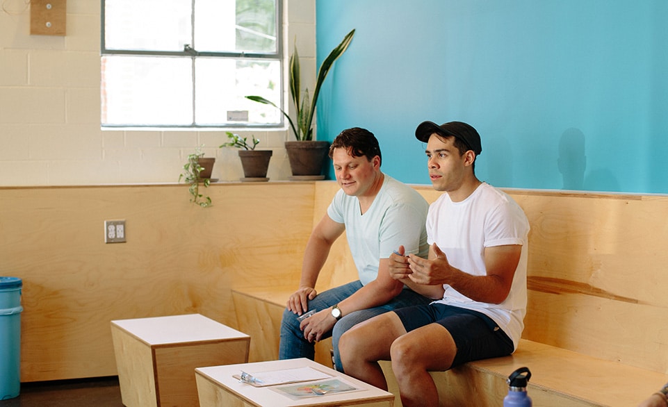 Mike and Radames Roldan, Blueprint Coffee's Director of Education, discuss the cupping with the staff at Blueprint Coffee Watson.