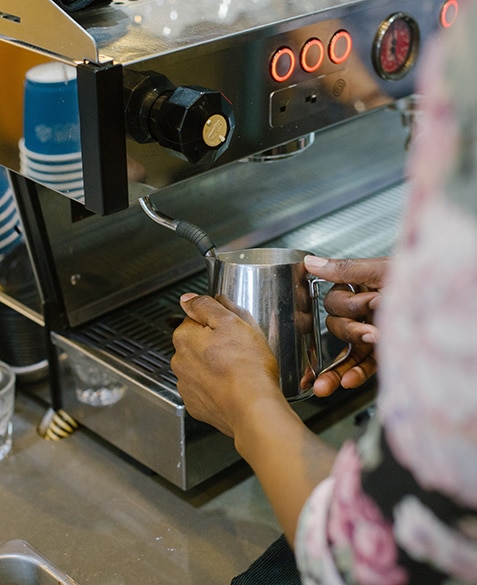 Janelle Johnson steams milk on the La Marzocco Linea PB at Blueprint Coffee Delmar.