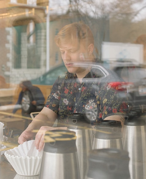 He grabs a coffee filter in preparation of brewing a batch of auto-drip coffee on the Fetco brewer.