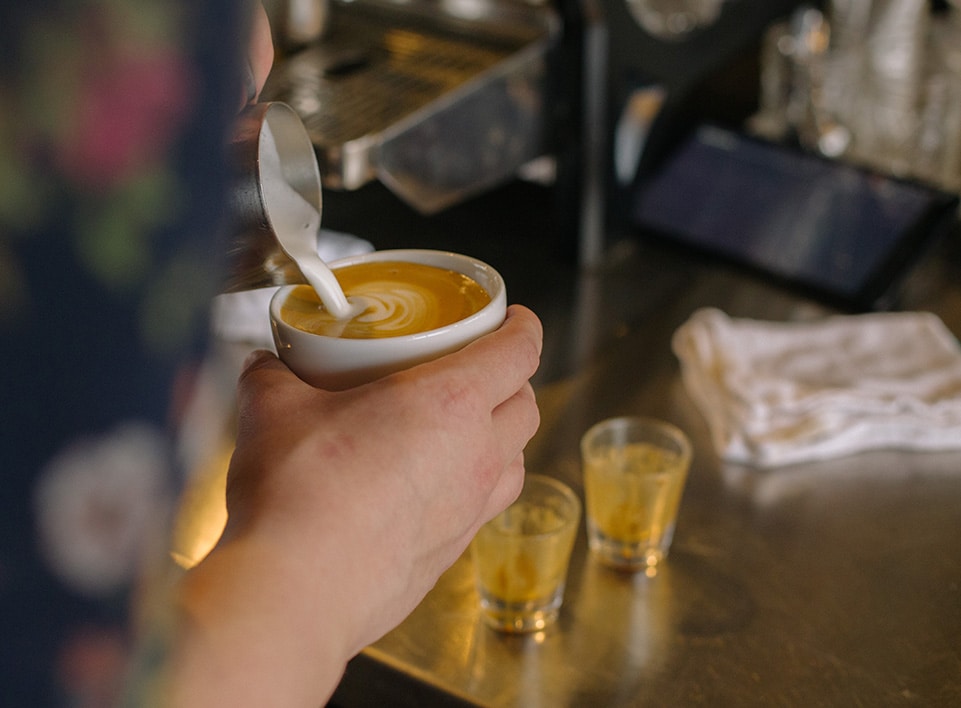 Alex Werth pours a cappuccino at Blueprint Coffee Watson.