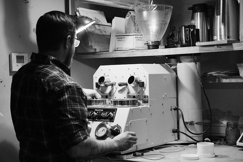 Andrew Timko at the sample roaster in the production area of Blueprint Coffee on Delmar Blvd.