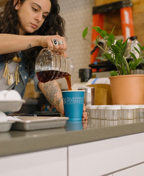 Ashley serves a pour-over coffee from the brew bar at Delmar.