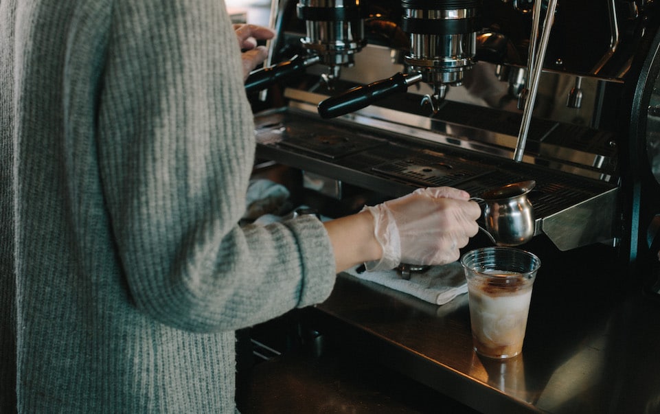 MG Batts making an iced coffee in front of an espresso machine
