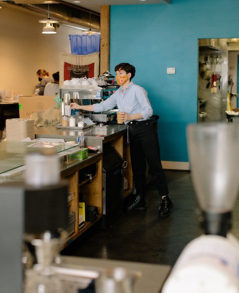 Mac makes an iced coffee near the espresso machine